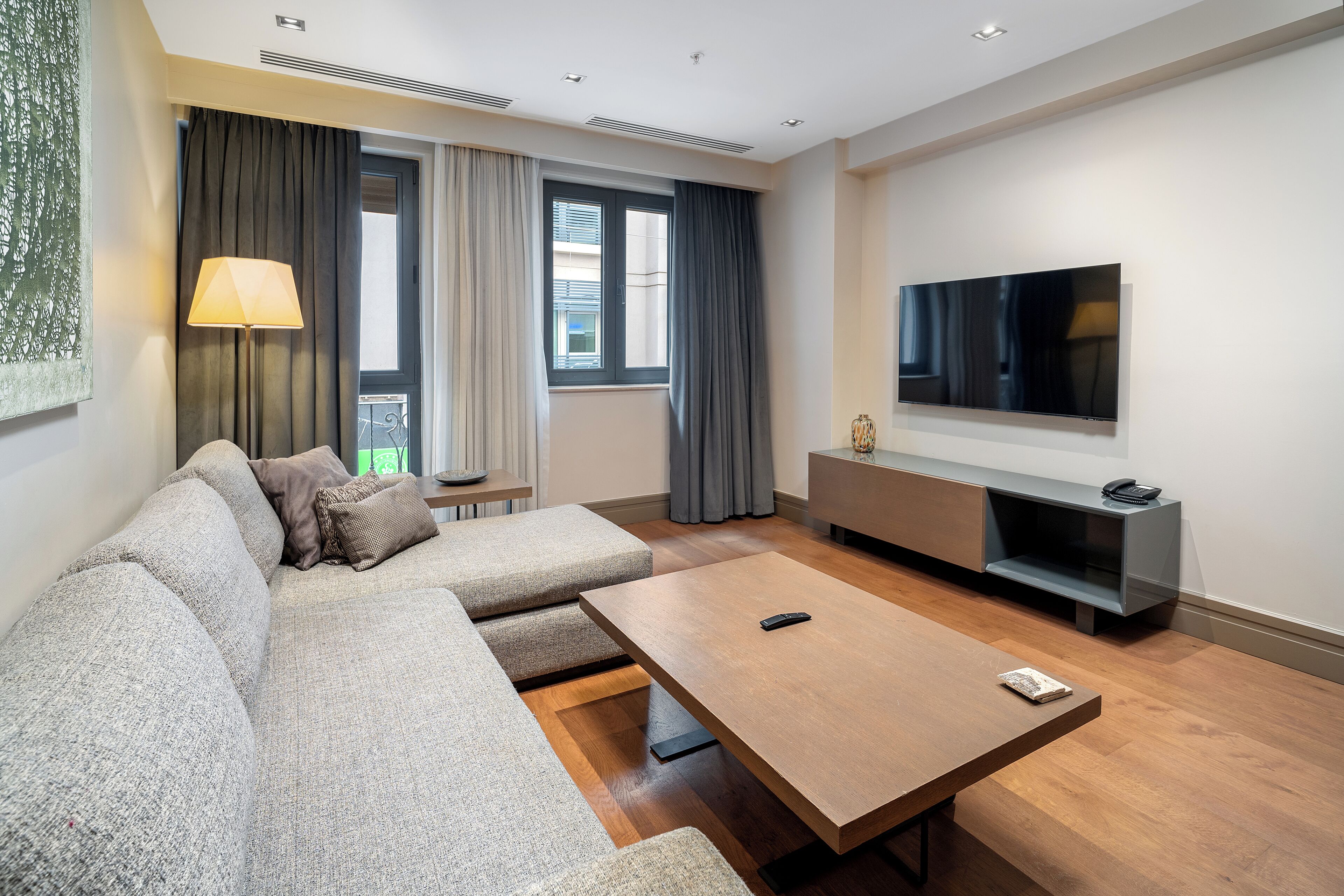 A modern living room with a sofa, a coffee table, a TV, and a small side table.