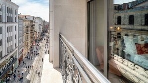 A balcony with a view of a busy street and a building with a large window. - Sentire Hotels&Residences Taksim (Istanbul)