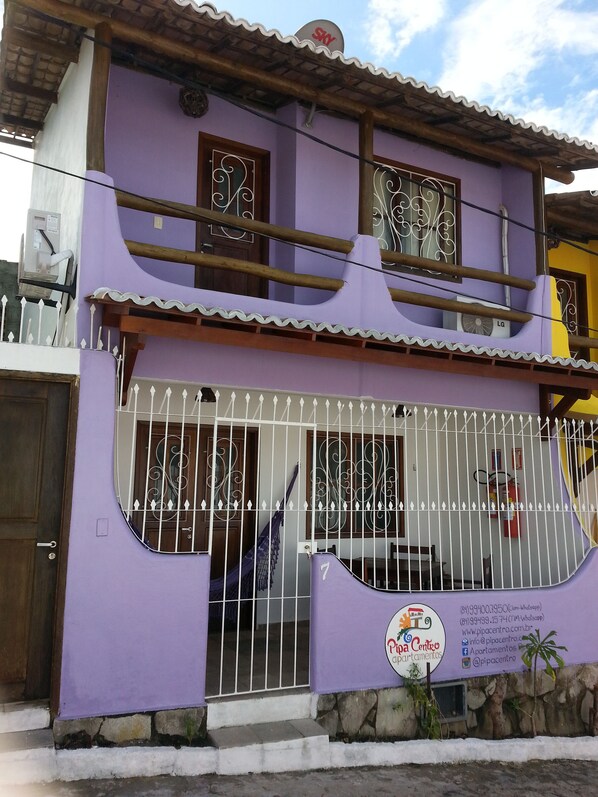 Ein zweistöckiges Gebäude mit violettfarbener Fassade, einem Balkon und einem verschlossenen Eingang.
