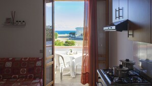 Una cocina con vista al mar, una mesa de comedor y un sofá.
