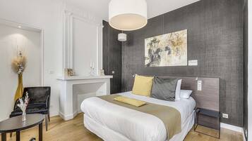 A modern bedroom with a large bed, bedside table, and a desk area.