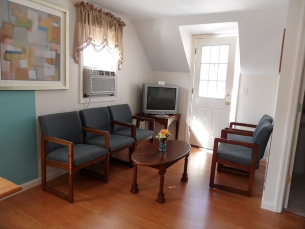 A living room with a sofa set, a coffee table, and a television.