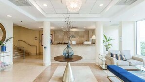 Un vestíbul modern amb una taula rodona, un sofà i una escala.
