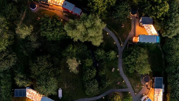 An aerial view of a residential area with multiple houses connected by pathways, surrounded by dense trees. - Cabin Sleeps 2 With Pets Welcome (Skegness)