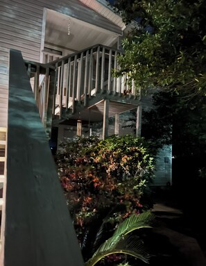 Ein mehrgeschossiges Gebäude mit Balkon und Garten.