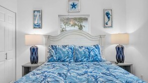 A bedroom with a bed, two nightstands, a window with blinds, and wall art. - Cozy Melbourne Retreat | Eau Gallie Arts | Wi-Fi (Melbourne)