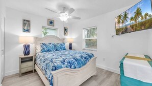 A bedroom with a bed, bedside tables, a ceiling fan, and a painting on the wall. - Cozy Melbourne Retreat | River front | Dock | Wifi (Melbourne)