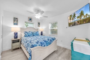 A bedroom with a bed, bedside tables, a ceiling fan, and a painting on the wall. - Cozy Melbourne Retreat | River front | Dock | Wifi (Melbourne)
