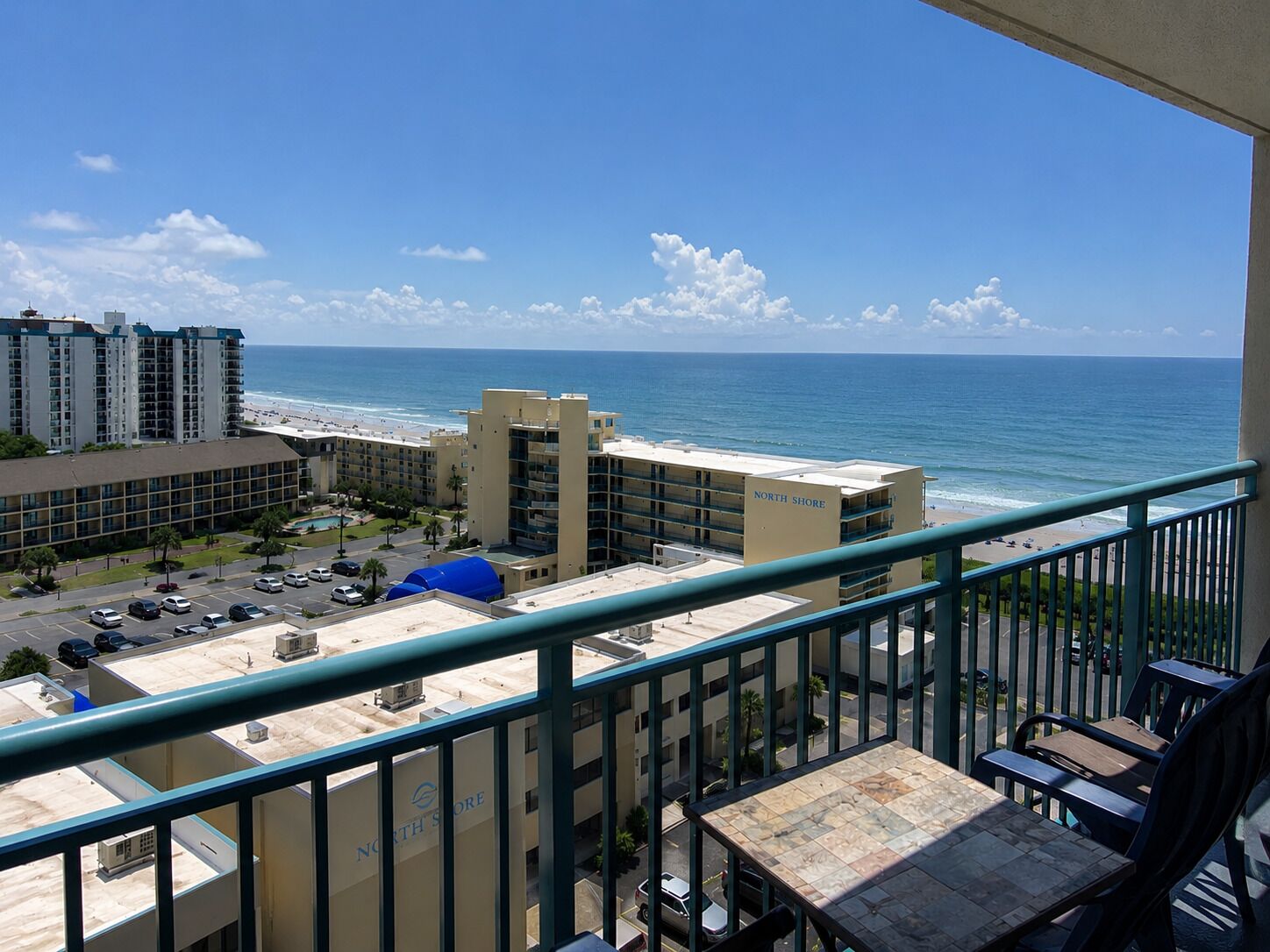 A balcony with a view of the ocean and a hotel building labeled 'North Shore'.