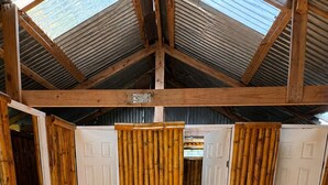 A room with a high ceiling, wooden beams, and a tiled floor.