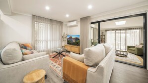 Una sala de estar moderna con un sofá, una mesa de centro y una televisión.