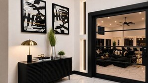 A modern living room with a black sofa, a black console table, and abstract art on the wall.