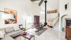 Ein großzügiger Wohnbereich mit Sofa, Esstisch und einer Treppe zu einer oberen Ebene.