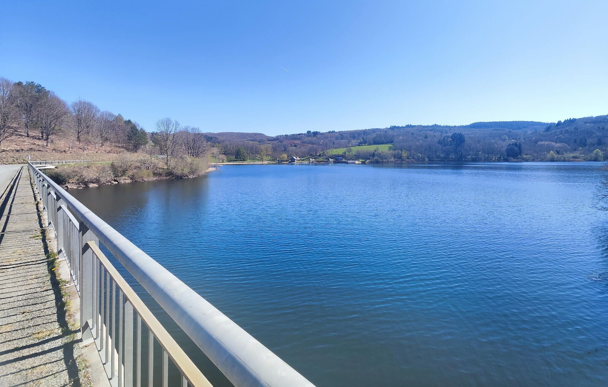 A bridge over a calm river with a clear sky.