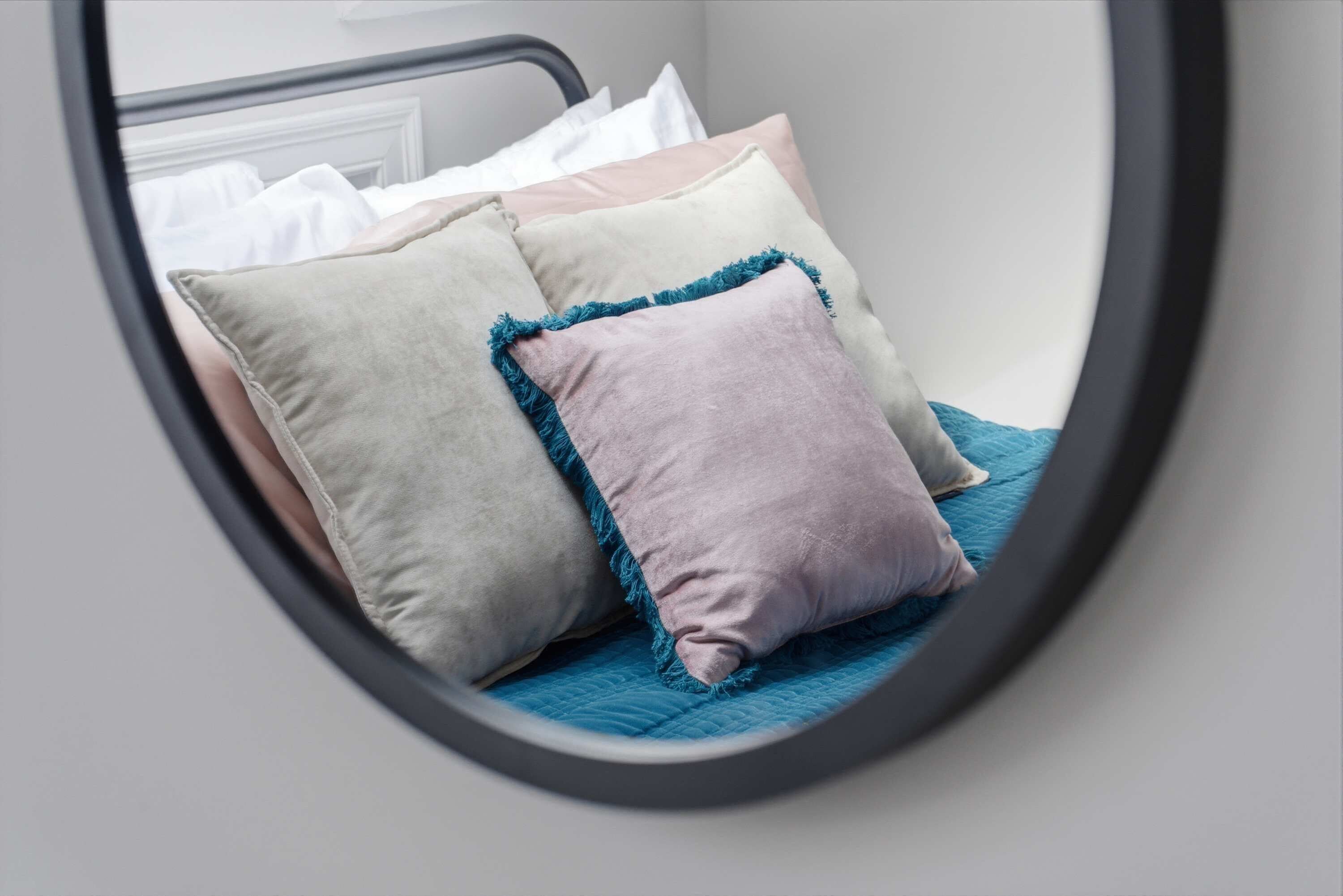 A bed with pillows and a blue blanket.