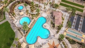 An aerial view of a resort with multiple swimming pools, a star-shaped sun patio, and a parking area. - Cozy 2-bedroom condo in beautiful Palm Desert with AC (Palm Desert)