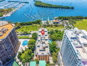 Ein Hochhaus-Hotel mit Pool auf dem Dach, eine Marina mit zahlreichen Booten und einem markanten Wahrzeichen.