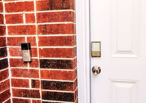 A white door with a doorbell and a keypad lock. - Empress Haven House (Cypress)