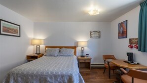 A hotel room with a bed, bedside lamps, a desk with a chair, and a coffee machine. - Clean, Modern & Close to Everything Double Room At Silversage Inn (Moab)