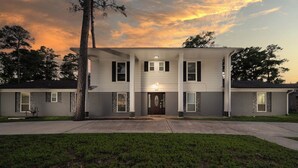 A two-story house with a front porch, a driveway, and a well-maintained lawn. - Empress Sunlit Villa (Cypress)