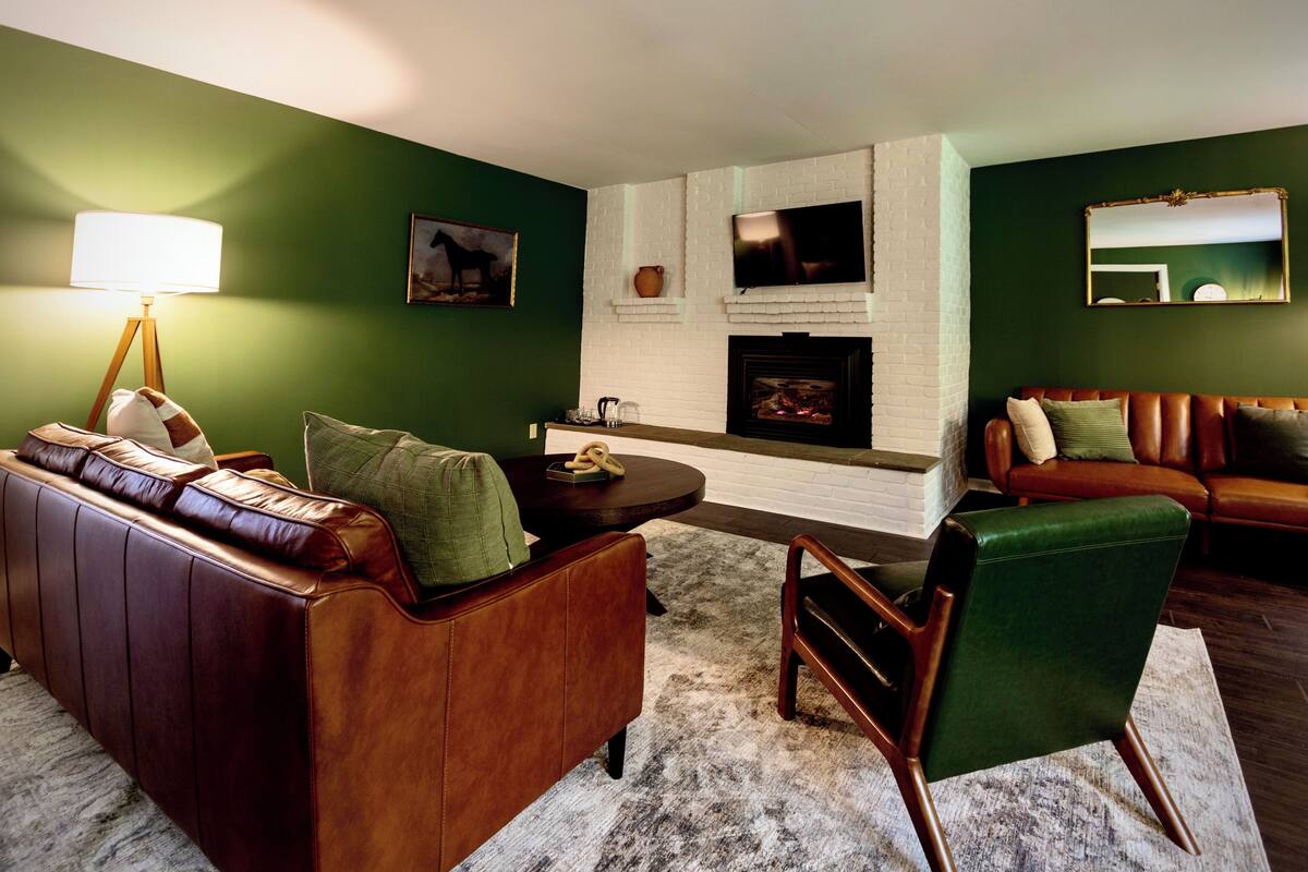 A living room with a fireplace, a sofa, a coffee table, and a television.