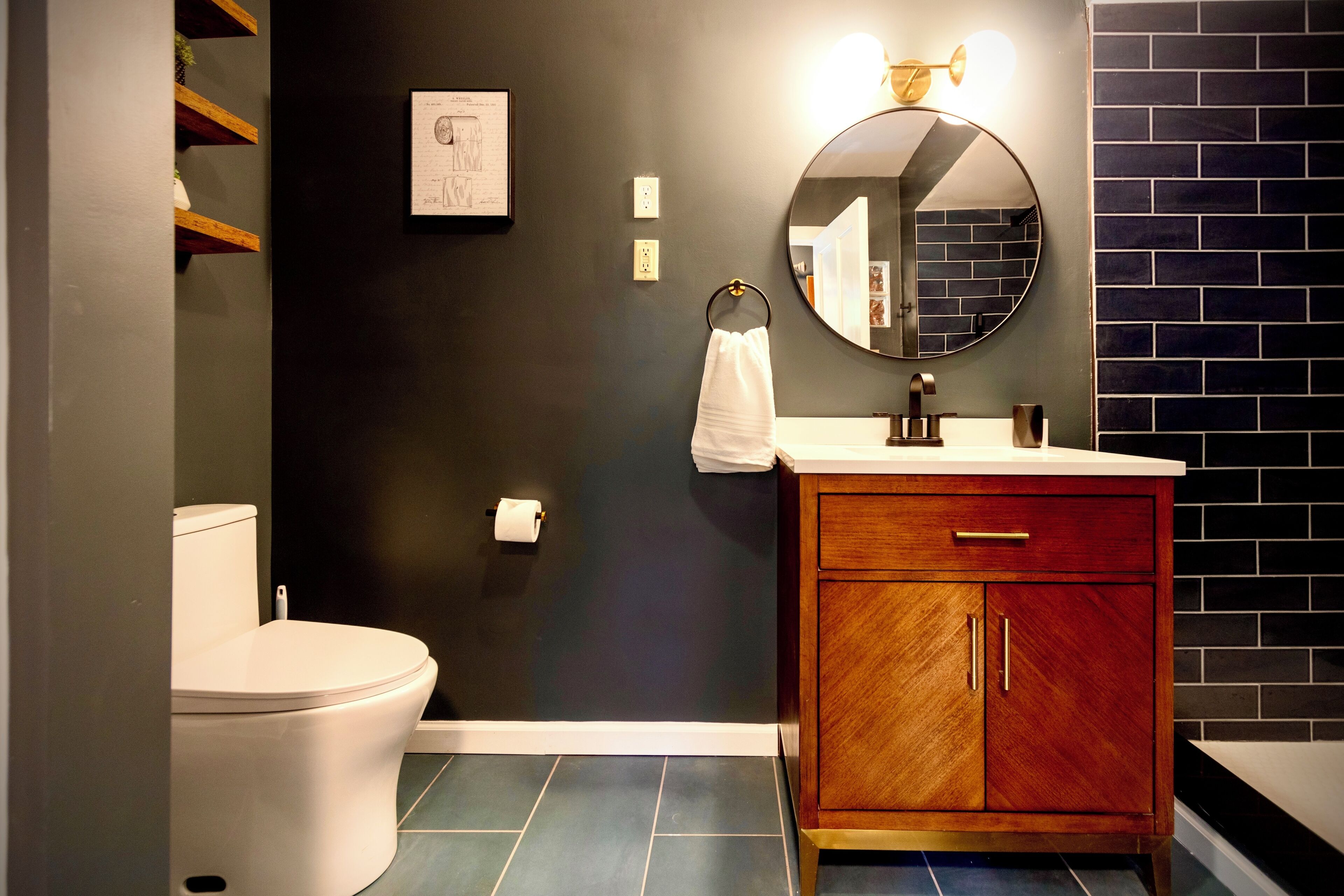 A bathroom with a toilet, a sink with a mirror, and a cabinet.
