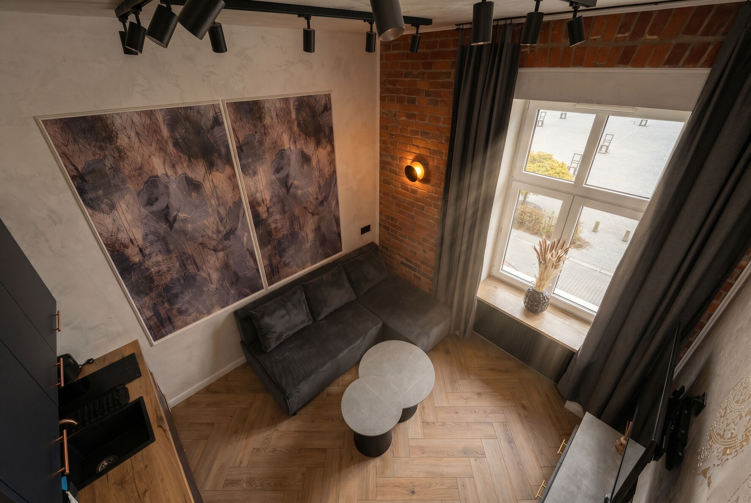 Una sala de estar moderna con un sofá modular, una mesa de centro redonda y un cuadro abstracto grande en la pared.