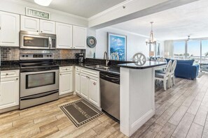A modern kitchen with white cabinets, stainless steel appliances, and a large island. - 312 Gorgeous Gulf Views w/ 25’ Private Balcony ~ Pool ~ Hot Tub ~ Book Aug 10th (Destin)