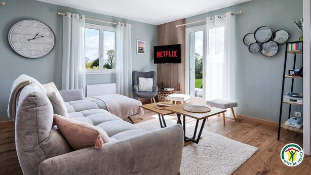 Ett modernt vardagsrum med en soffa, en tv och en bokhylla.