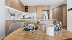 A modern kitchen with a built-in island, white marble backsplash, and wooden cabinetry. - Luxury High-Rise Stay with Panoramic GC Views (Broadbeach)