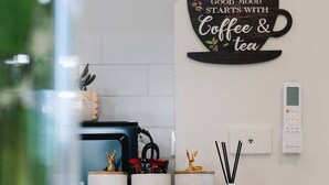 Un comptoir de cuisine avec une machine à café, un service à thé et des objets de décoration.