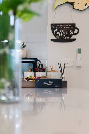 Eine Küchenarbeitsplatte mit Kaffeemaschine, Teeservice und Dekoration.