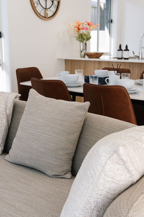 Una sala moderna con un sofá, una mesa de comedor y sillas.