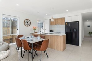 Una cocina moderna con una isla central, mesa y sillas.