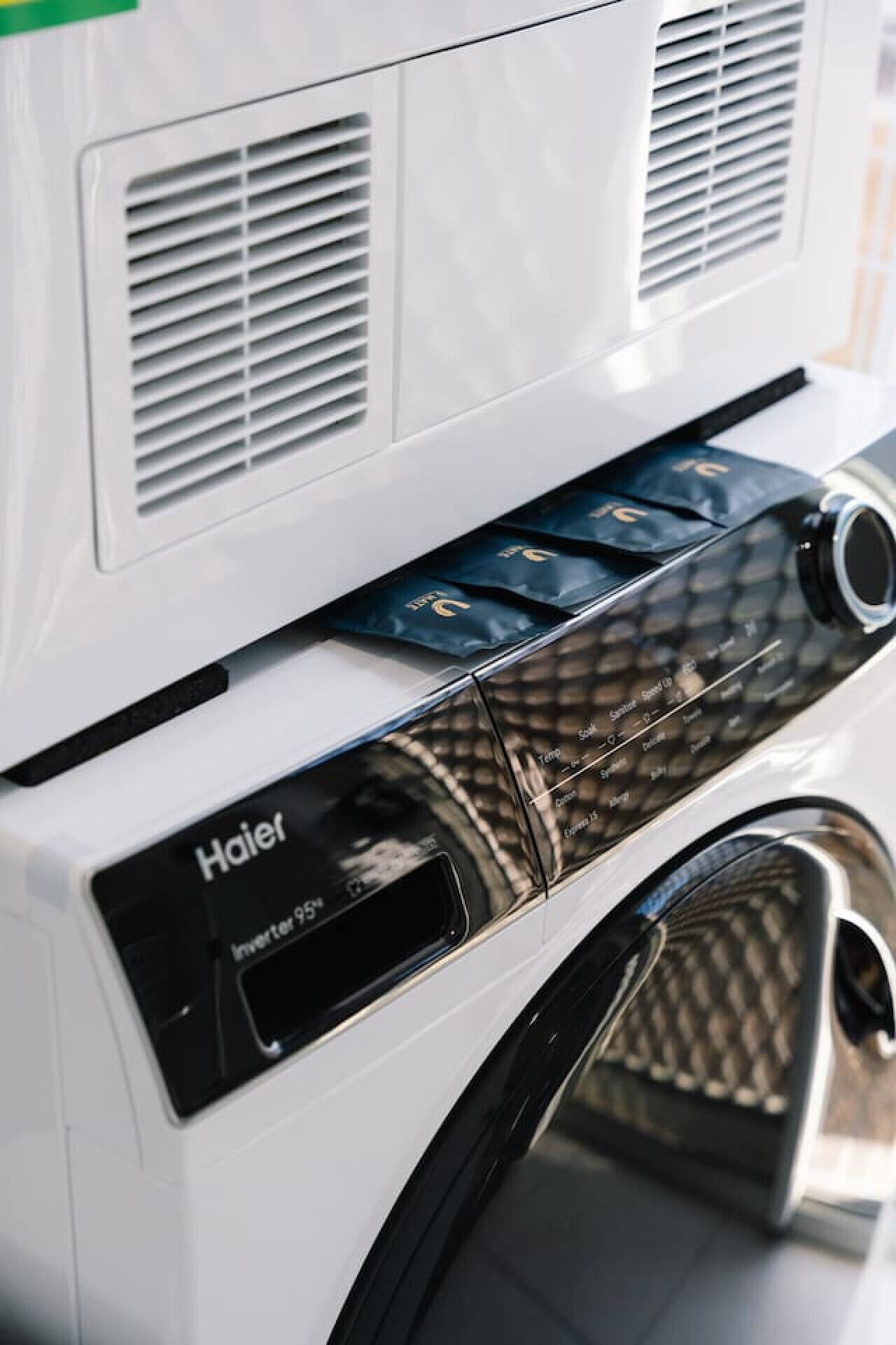 A white appliance with a control panel labeled 'Haier' and a 'Inverter 95' feature.