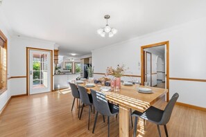 Ein Essbereich mit Holztisch, Stühlen und einer Küche im Hintergrund.