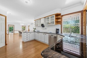 Een moderne keuken met witte kasten, een vaatwasser en een granieten werkblad.