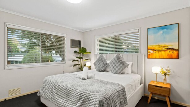 A neatly arranged bedroom with a bed, bedside tables, and a painting on the wall. - Affordable Stay | Private & Convenient |Near Shops (Jindalee)