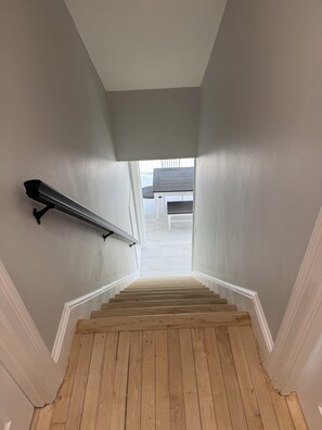 Eine Holztreppe mit weißen Wänden und einer Handläufe.