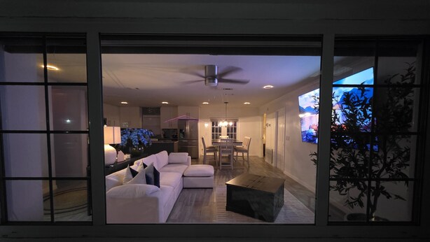 A modern living room with a sofa, coffee table, and TV. - Pool Home + BBQ Grill + Family Friendly in Orlando, FL! (Orlando)