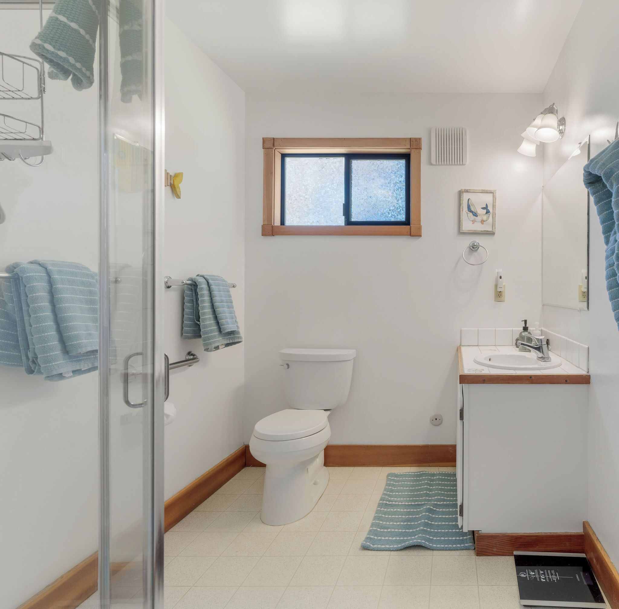 Une salle de bain comprenant des toilettes, un lavabo et un espace douche.