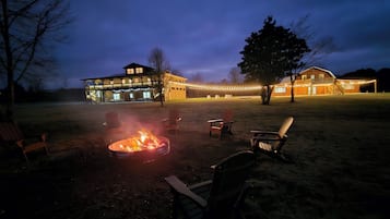 A large building with multiple windows and a fire pit in the foreground.