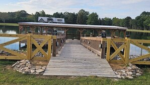 Une jetée en bois mène à une zone abritée, où un panneau indique qu’il s’agit d’un endroit où l’on peut pêcher.