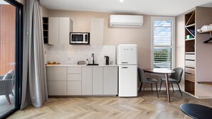 Una cocina moderna con microondas, refrigerador y comedor.