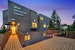 Moderni rakennus, jossa on kyltti, jossa lukee ”Blue Diamond Lodge”, puinen terassi ja portaat, jotka johtavat sis äänkäynnille.