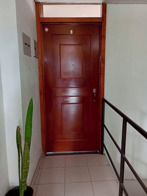 A wooden door with a metal handle, a potted plant, and a tiled floor. - Bright 3BR in Central Cajicá. Walk to Plaza. Near Zipaquirá & Tabio (Cajicá)