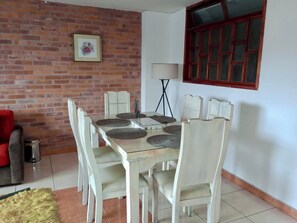 A dining area with a brick wall, a framed picture, a lamp, and a window. - Bright 3BR in Central Cajicá. Walk to Plaza. Near Zipaquirá & Tabio (Cajicá)