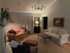 A living room with two sofas, a coffee table, a lamp, a mirror, and a painting on the wall. - Cozy 3 bedroom in west Little Rock-outdoor covered deck w grill (Little Rock)