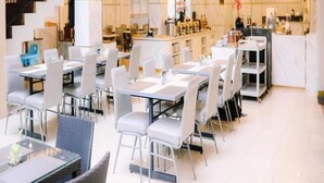 A modern hotel lobby with a staircase, dining area, and reception desk. - Grand Malioboro Hotel Yogyakarta (Yogyakarta)