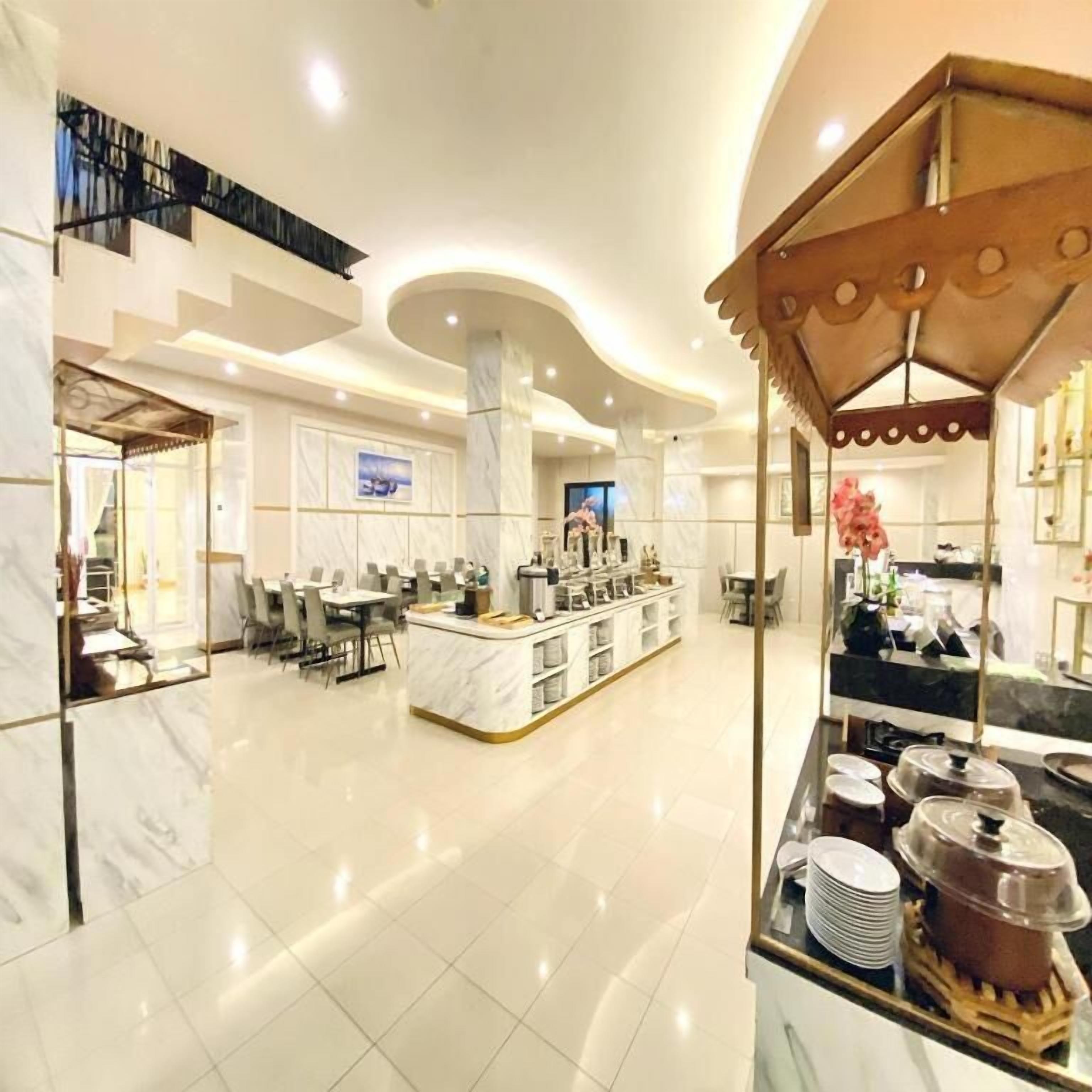 A spacious hotel lobby with a central island, seating areas, and a modern ceiling design.